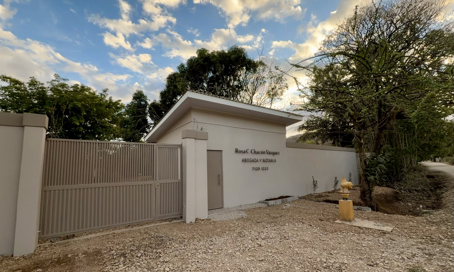 Exterior de la oficina de Rosa C. Chacón Vásquez en Nicoya, rodeado de árboles